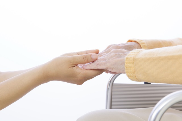 介護者と老人の手